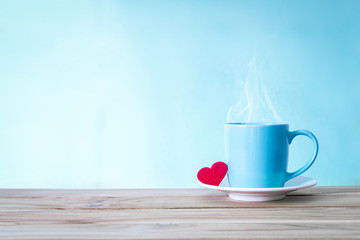 Coffee cup mug with red heart shape on wooden table , Romance