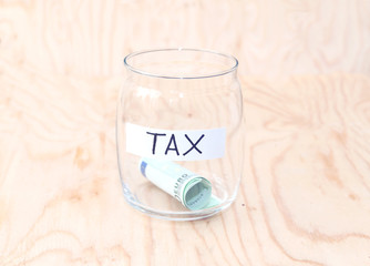 Money jar with money on wood table , Saving for Tax Concept. Time to pay