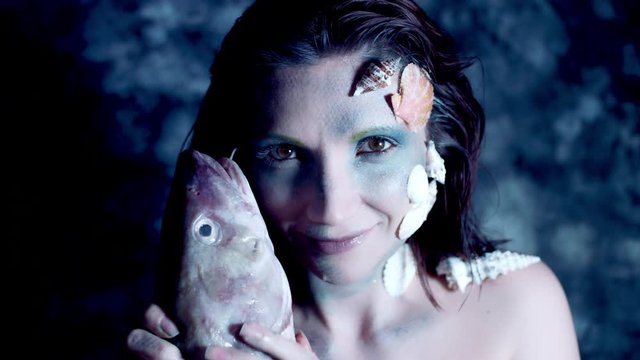 4k Halloween Shot of a Horror Woman Mermaid Petting a Real Fish