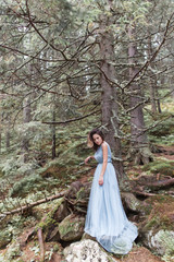 beautiful sweet girl bride in her wedding dress light air in the mountains near the lake, a beautiful landscape of mountains