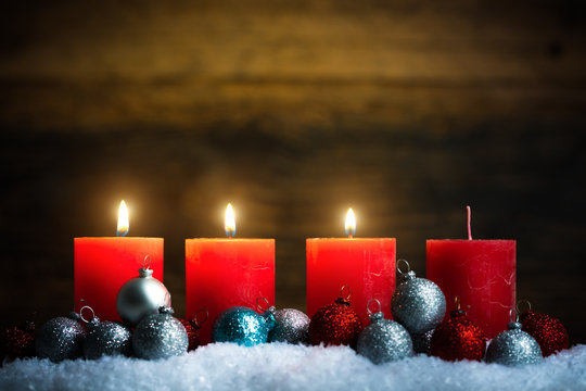 Weihnachtsschmuck und 4 Kerzen von denen drei symbolisch für den 3. Advent leuchten