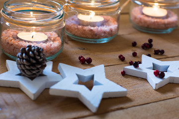 Handmade tea lights in jars with salt, wood decoration stars, red berries, Christmas, New Year, advent