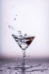 Beautiful water splash in martini glass falling