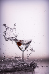Beautiful water splash in martini glass from a cherry