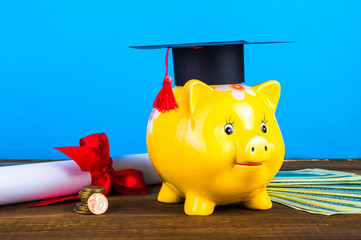 Piggy bank with grad hat and diploma