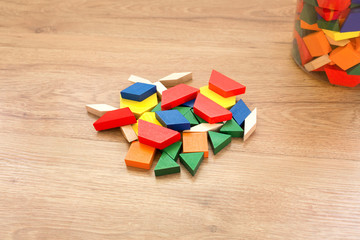 Multicolored pattern blocks on a dark wooden background