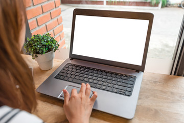Fototapeta premium Woman using laptop with blank screen on table at coffee shop