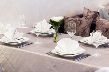 Empty glasses and dishes set in an interior new luxury restaurant with covered tables