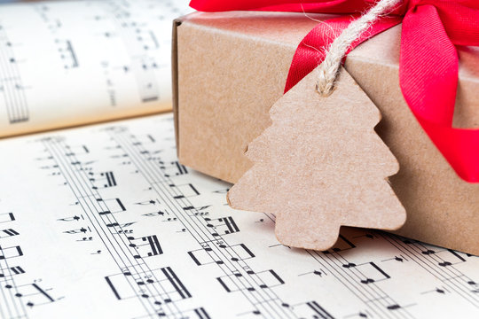 Christmas Present With Label And Twine On Music Sheet