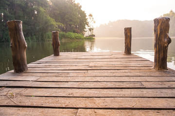 Old wooden pier bridge over the lake in the morning