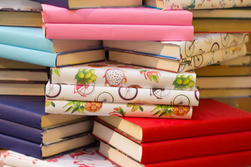 bright stack of books many books are in a pile, mixed and colorful background and substrate