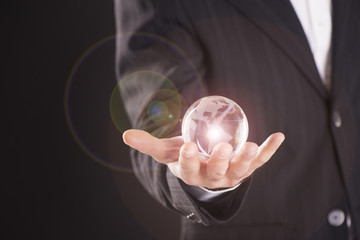 Businessman holding a glass ball
