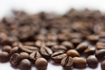 Close up beans on a white background. Coffee on the entire screen for the background. Roasted coffee beans brown. Lots of coffee in high definition.