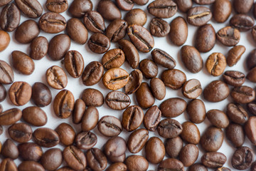 Close up beans on a white background. Coffee on the entire screen for the background. Roasted coffee beans brown. Lots of coffee in high definition.