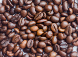 Obraz premium Close up beans on a white background. Coffee on the entire screen for the background. Roasted coffee beans brown. Lots of coffee in high definition.