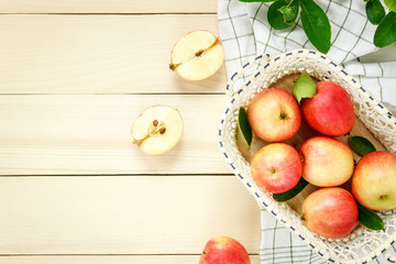 Top view red apple and leaf in basket on wooden.