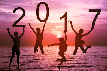 Happy new year card 2017. Silhouette of children girl in jumping on tropical beach with fantastic...