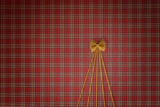 Christmas tree made of pasta on red squared background. Flat lay. Top view. Winter holidays concept