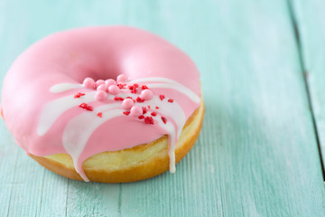 pink doughnut on turquoise wooden background