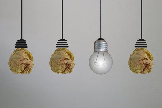 Ceiling lamp designed by crumpled paper on gray concrete wall.