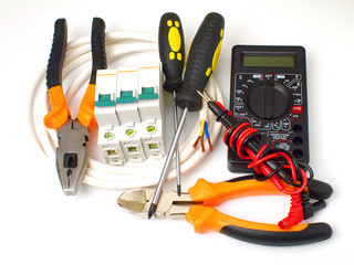 set of electrician tools and equipment and a coil of wire on a white background, closeup, focus on...