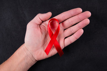 Red ribbon as symbol of aids awareness in men's hand