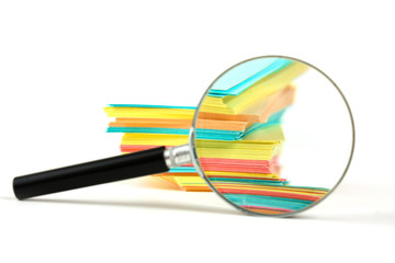 magnifying glass and a stack of paper