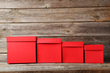 Stacks of red boxes on grey wooden table