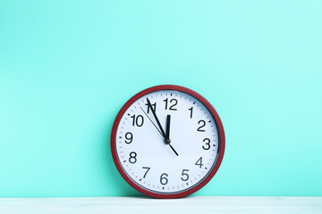Red round clock on a mint background