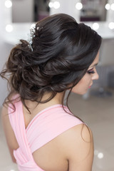 beautiful elegant evening hairstyle on dark hair beautiful girl with an ornament from stones in her hair, hairstyle for the wedding