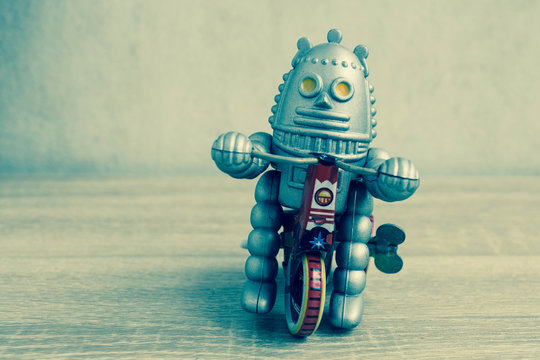 Old robot toy on wood table, vintage color style, vintage tone background.