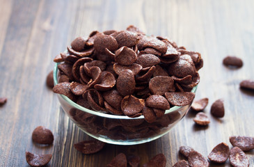 chocolate flakes on bowl on brown background