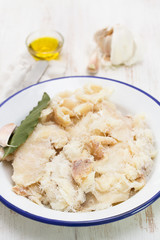 dry cod fish on dish on wooden background