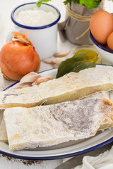 salted codfish on dish with potato and onion