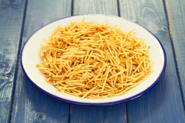 potato chips on white plate on wooden background