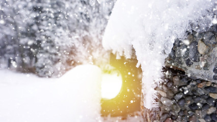Snow covered trees and bench in the park with sun ray effect