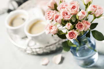 Obraz na płótnie Canvas Romantic setup with coffee and roses in vase
