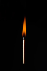 one burning match on a black background