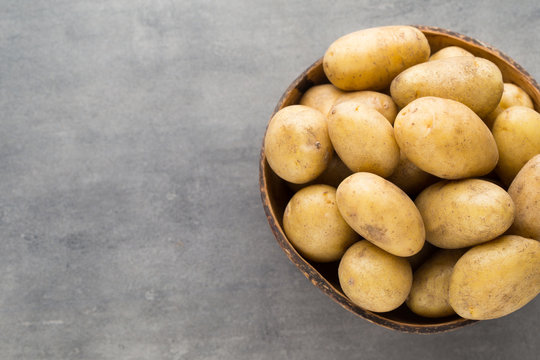New potato on the bowl, gray background.