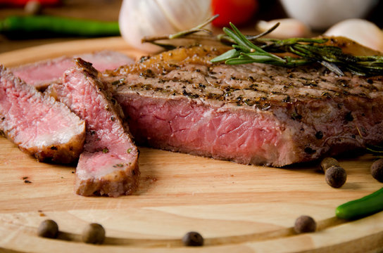 rare steak round wooden cutting board spices