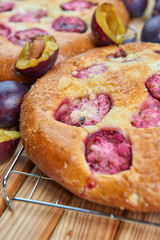 Home made plum buns on a wooden table
