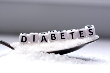 Diabetes word from letter blocks with spoon and sugar