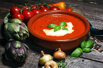 Tomato, red pepper soup, sauce with olive oil, rosemary and smoked paprika on a wooden background.