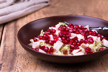 Healthy salad with pomegranate seeds, chicken and cabbage.