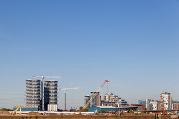 Building crane and construction site under blue sky.