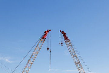 modern construction cranes in front of blue sky.