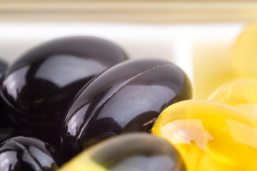 Mixed natural food supplement pills, vitamin a, carotene, omega 3, vitamin e, capsules macro image.