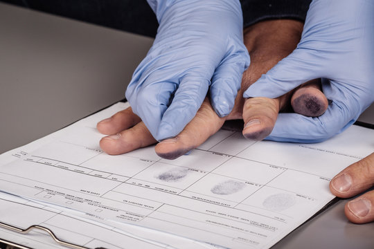 police takes fingerprints of a criminal