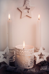 White candles and wood stars Christmas and New Year decoration in vintage style, toned