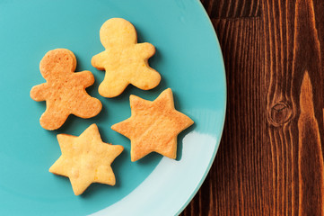Gingerbread cookies man and star shape in turquoise plate on woo